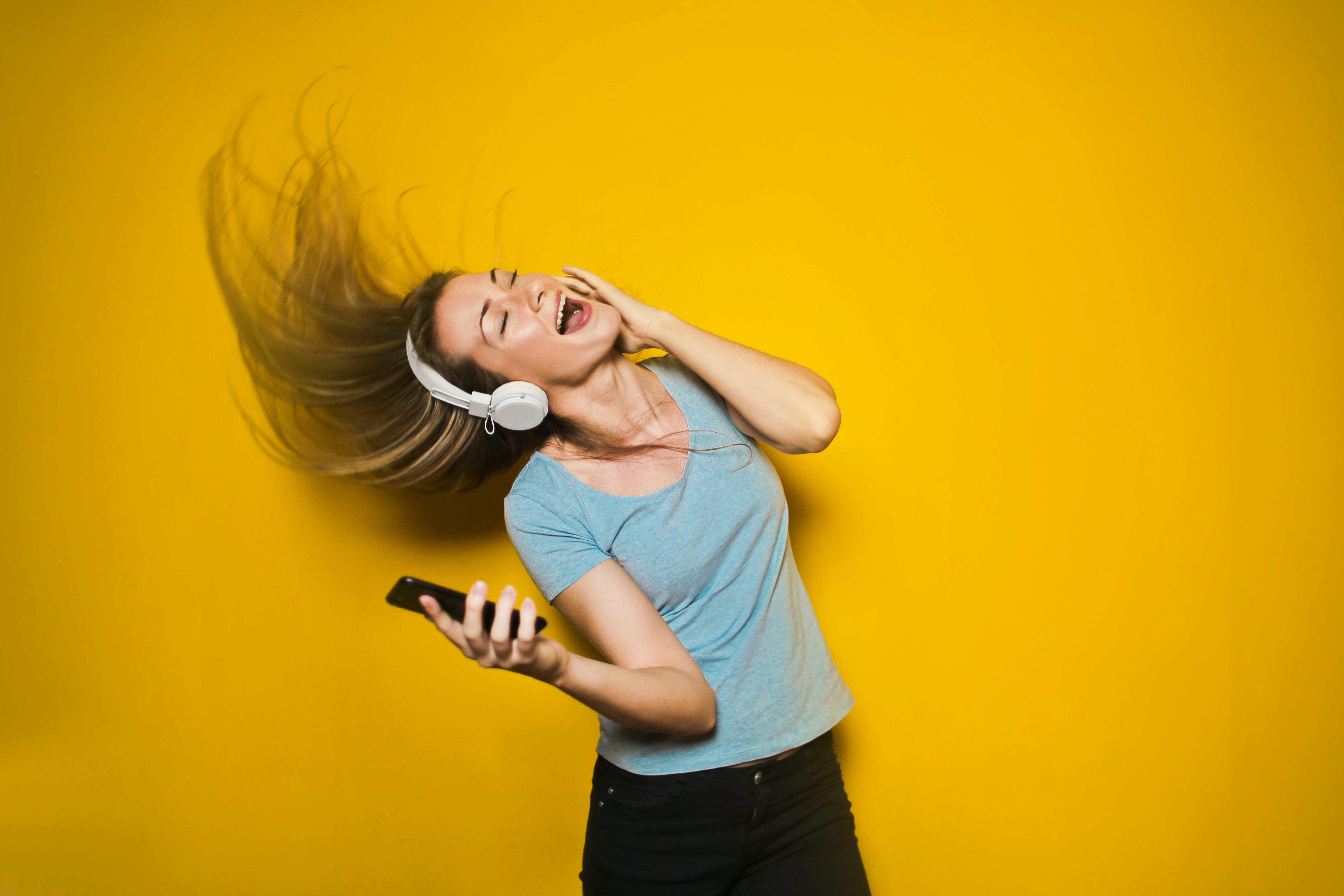 Teen-aged girl dancing with headphones on.