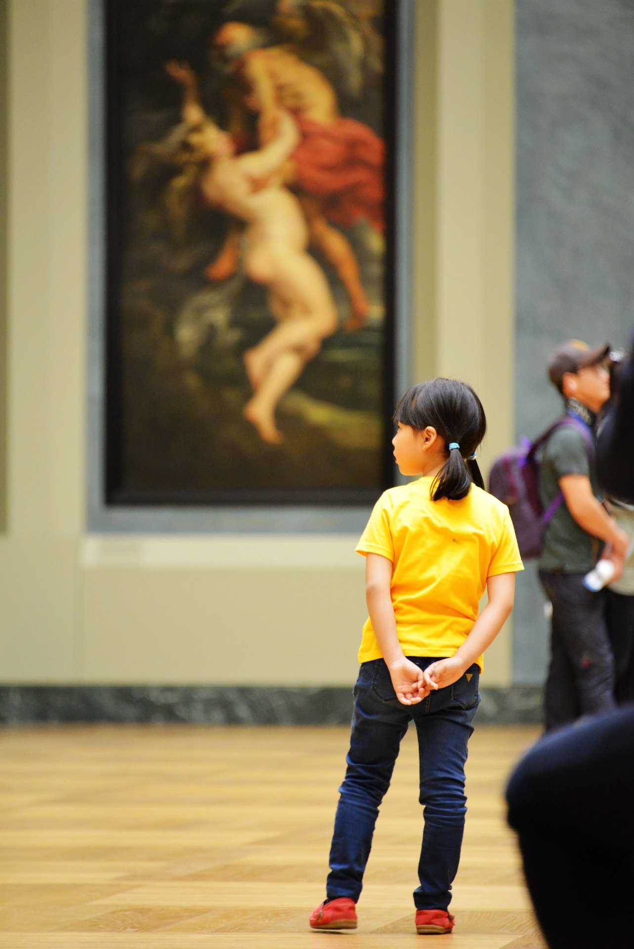 Child standing in front of an art piece in a museum