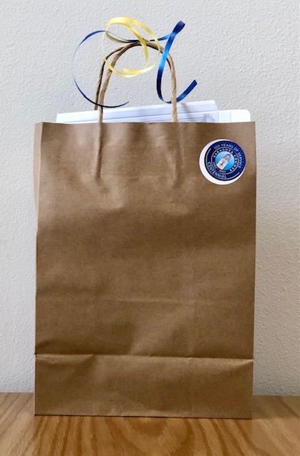 brown paper bag with sticker and ribbons