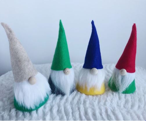 four mini gnomes sit in a colorful line