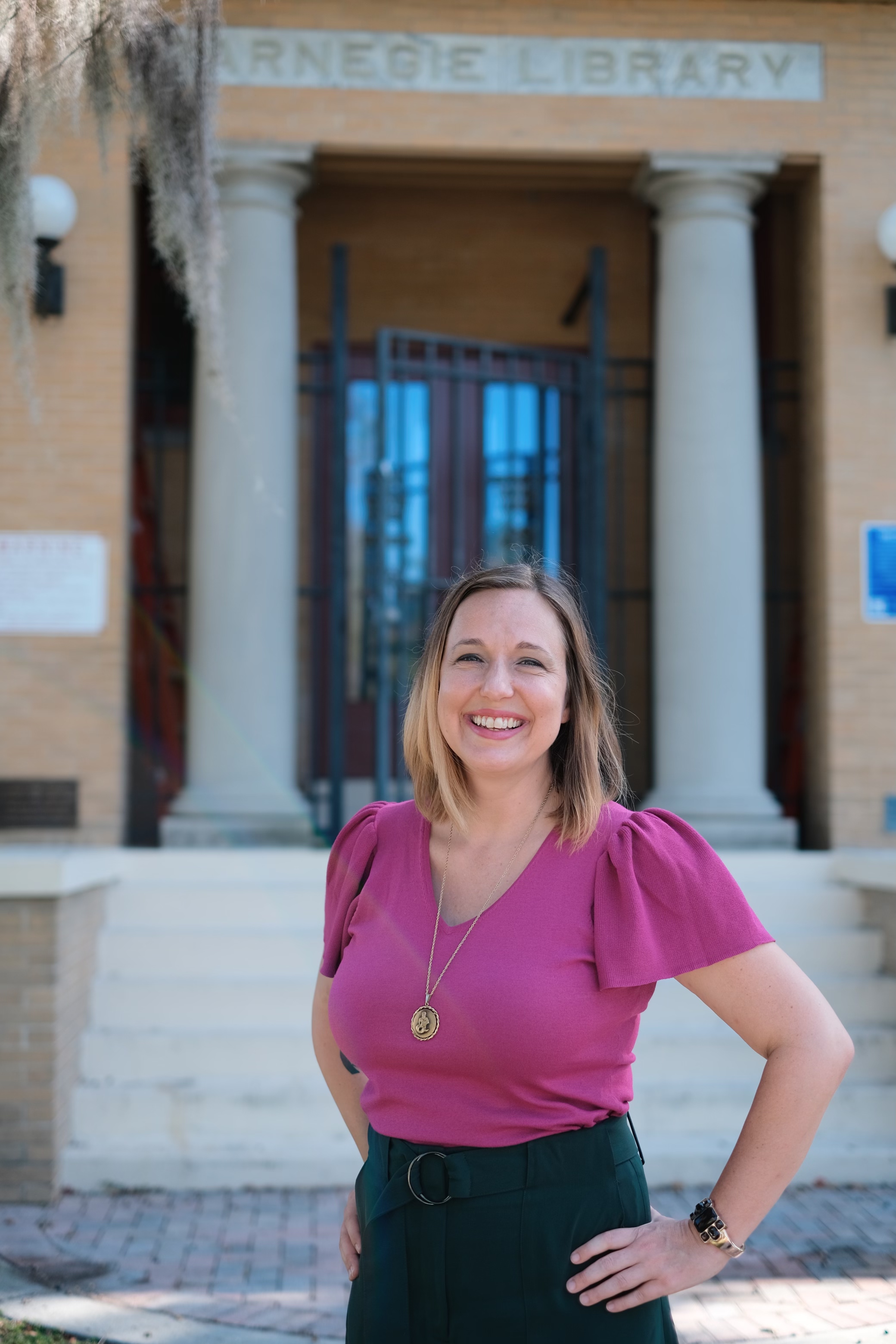Photo of author Andrea Knies  in front of a library
