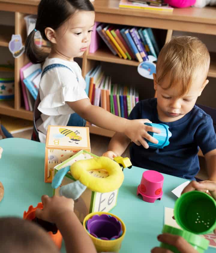 Two toddlers playing with early learning toys at a library