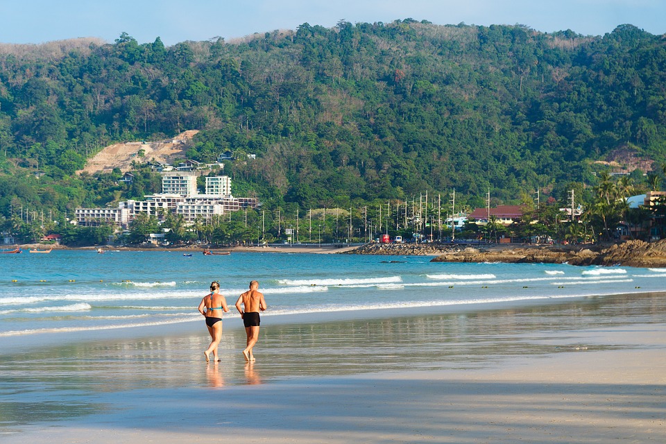 Couple walking on beach in swim suits