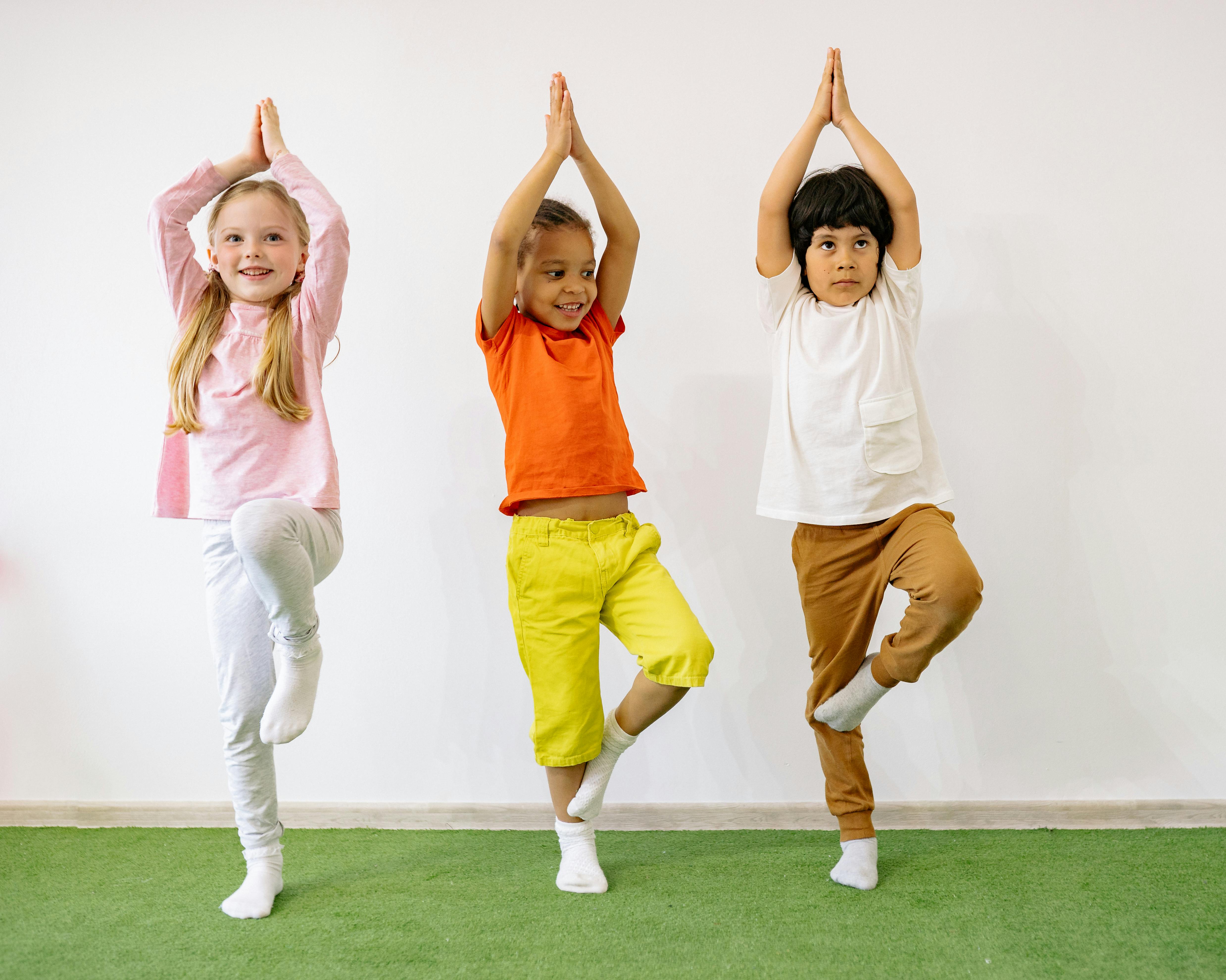 Three children performing a yoga or exercise pose