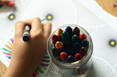 Small child coloring with crayons.