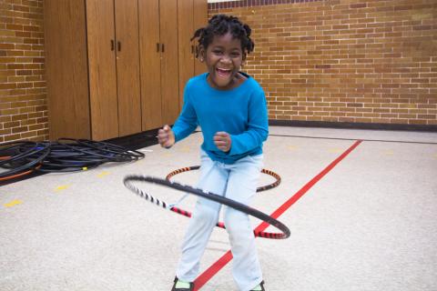 A little girl hula hooping.