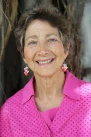 Photo of author Jane Plitt in pink top posing in front of a tree.