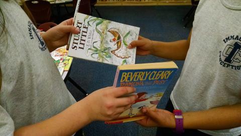 Two children trading books.