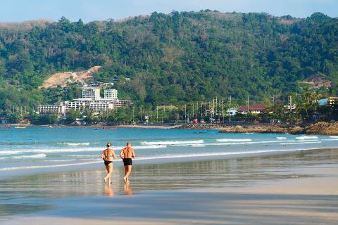 Couple walking on beach in swim suits