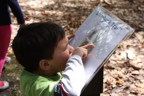 Child reading a sign at a playground