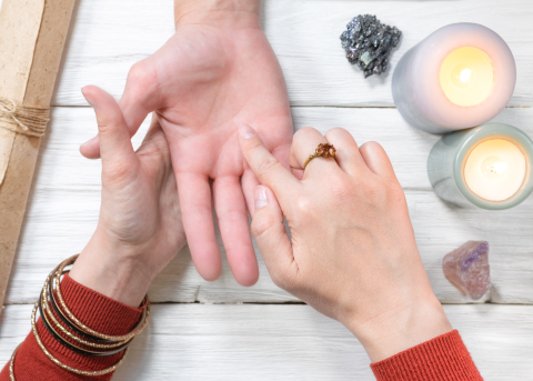 A picture of someone giving someone else a palm reading.