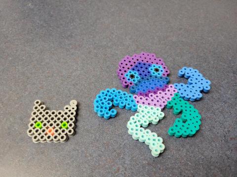 Cat face and octopus made with perler beads.