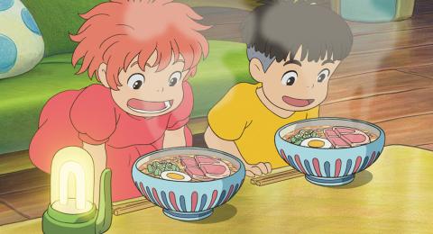 Two children looking into steaming bowls of food.