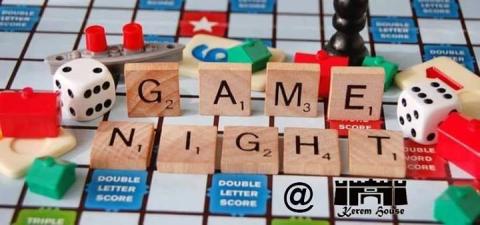 The words Game Night spelled out using Scrabble game tiles on a game board. 