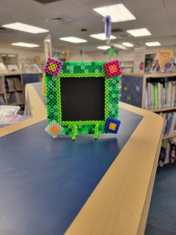 Green picture frame made with fused Perler beads.