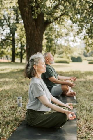 two people doing yoga outside