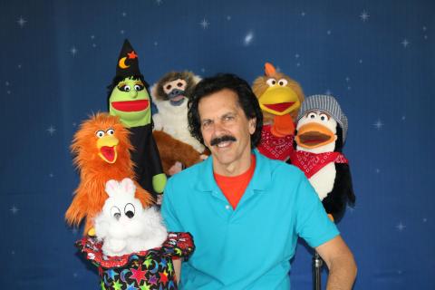 James Chartier surrounded by puppets