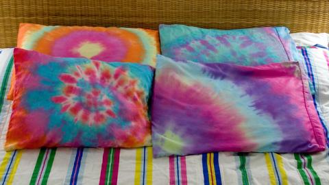 Multiple pillows that have a tie dye pattern