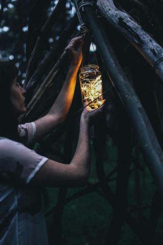 woman hanging mason jar lamp