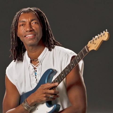 Photo of musician Karlus Trapp holding an electric guitar.