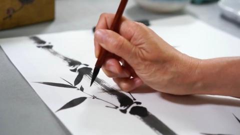 Image of a hand painting with black paint