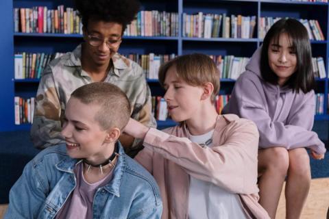 group of teens sitting in a library