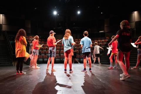 Kids of various ages standing on a stage.