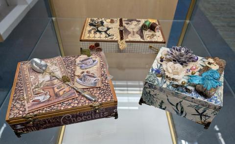 Various cigar-style boxes decorated with seashells, sewing notions and vintage photos.