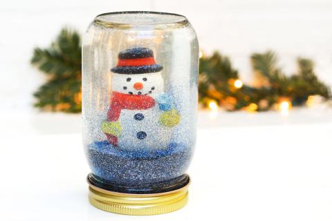 Mason jar filled with snowman and blue glitter