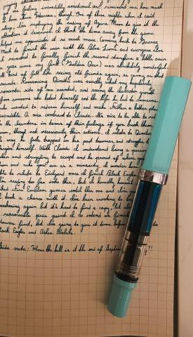 Fountain pen lays on top a cursive journal entry.