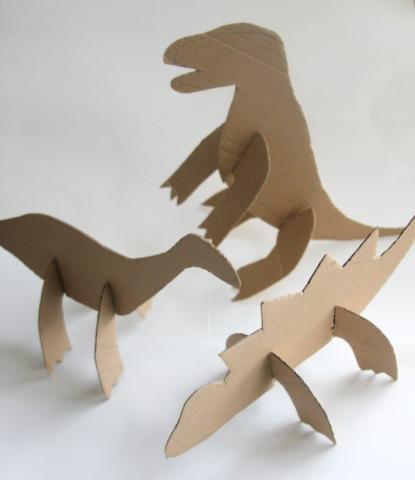 3 cardboard dinosaurs with a white backdrop 