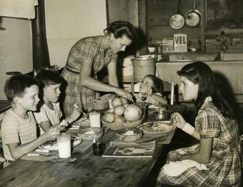 A family gathers around the dinner table for a home cooked meal. 