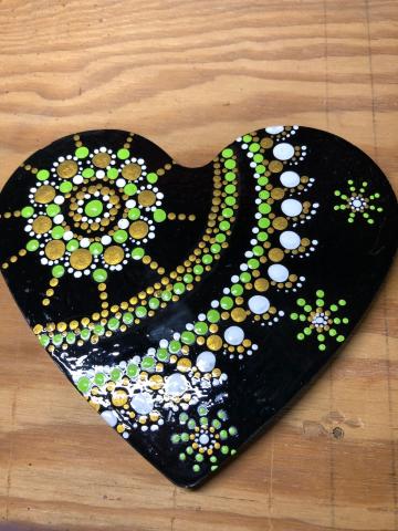 Heart shaped mandala with green, white, and gold dots.