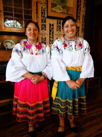 two smiling women dressed in traditional Ecuadorian clothing