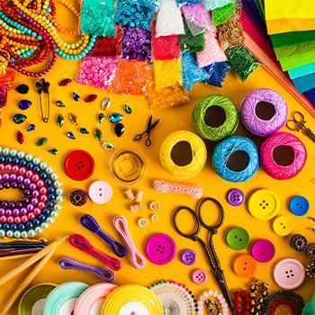 a yellow background with a colorful array of craft supplies. 