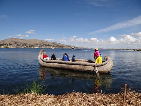 a group of people riding on a traditional canoe in Peru