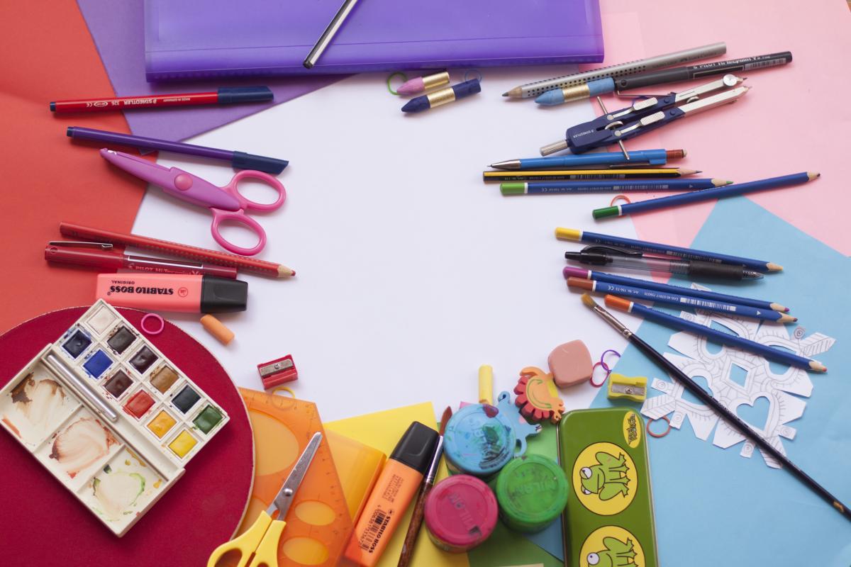 Art supplies arranged on colorful paper.