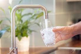 water flowing from a tap into a glass of ice