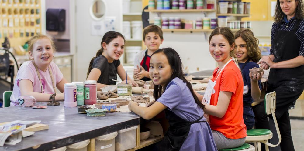 Group of children making crafts in a classroom setting.