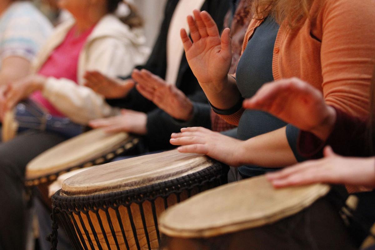 3 drums with hands drumming on them.