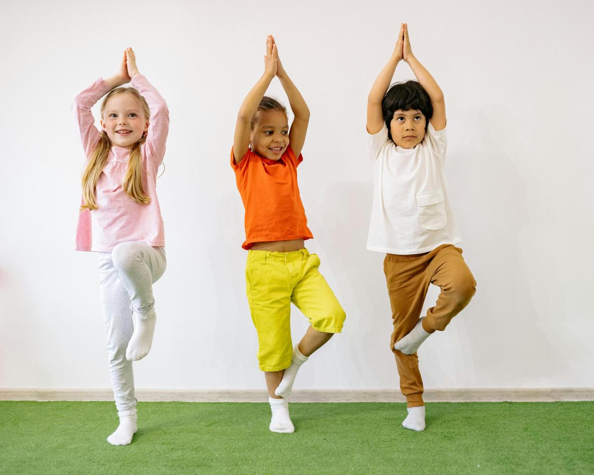 Three children performing a yoga or exercise pose.