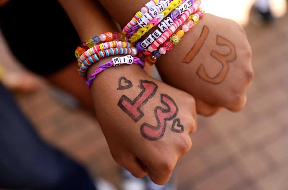 2 hands displaying the number 13 and multiple beaded friendship bracelets.
