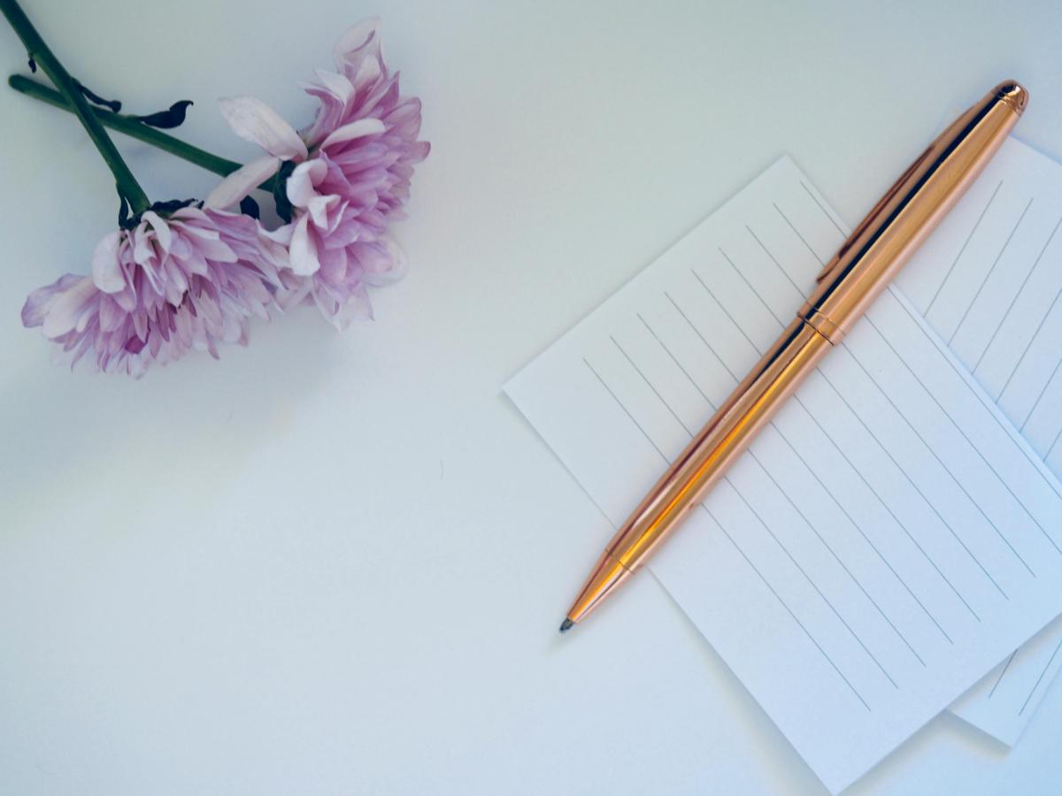 pen and paper with a pink flower