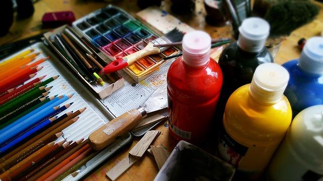 Bottles of brightly colored acrylic paints and a palette