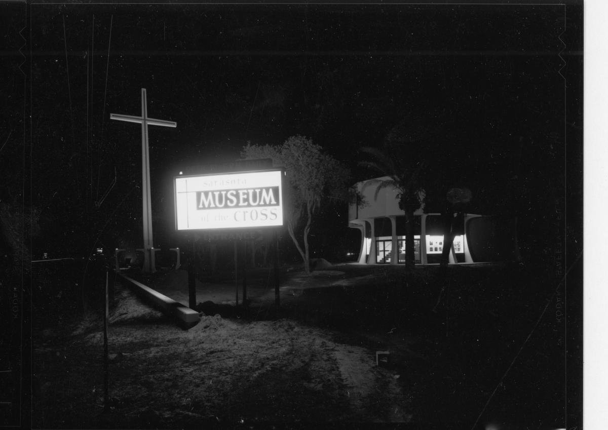 A black and white photograph of the entrance sign for the Museum of the Cross