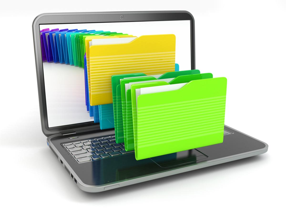Brightly colored file folders sitting on an open laptop.