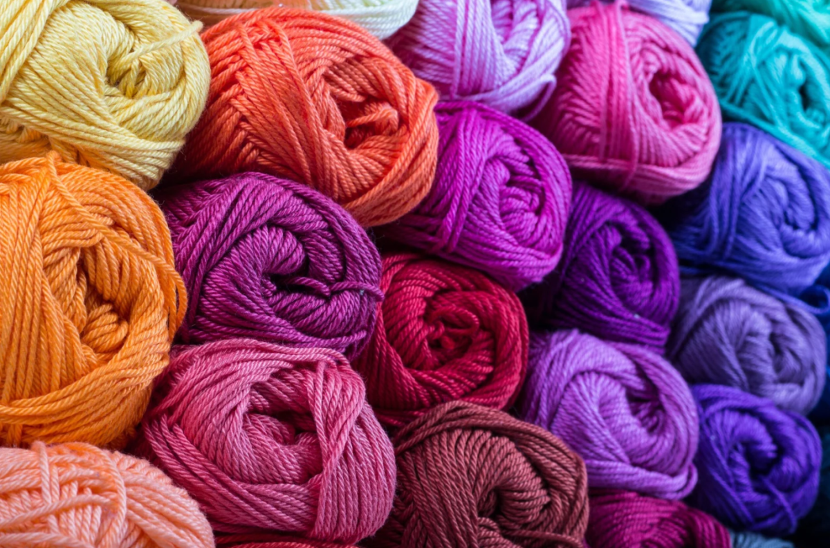 Different colored yarns stacked on top of one another forming a wall