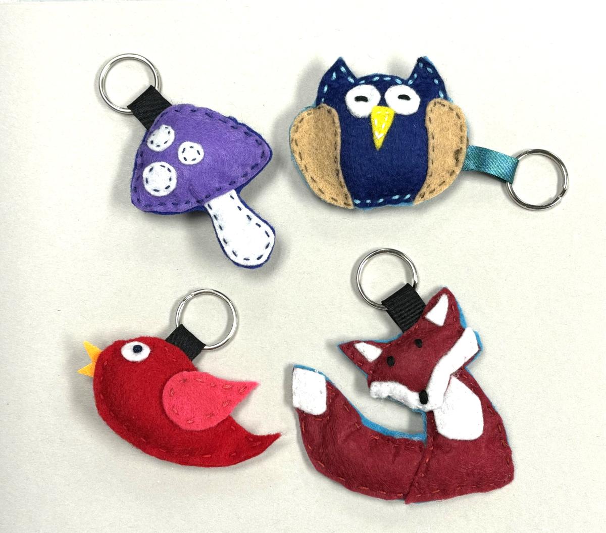 Four handmade keychains of an owl, bird, fox and mushroom