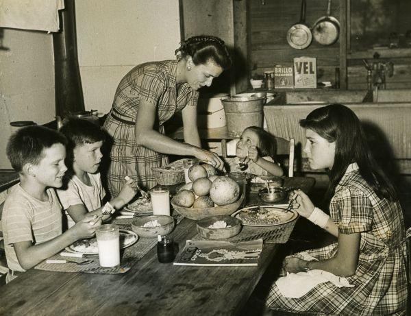 A family gathers around the dinner table for a home cooked meal. 