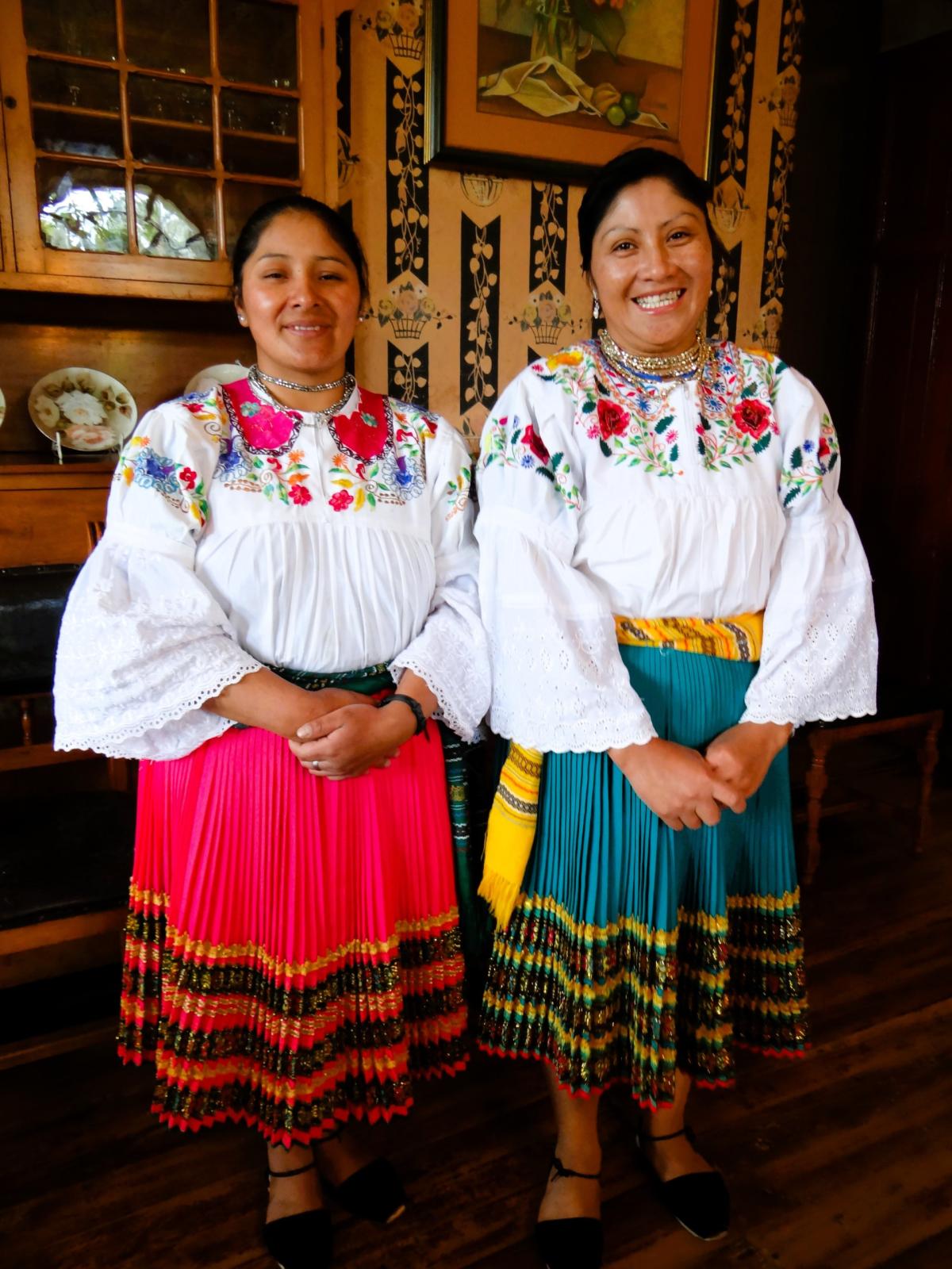two smiling women dressed in traditional Ecuadorian clothing